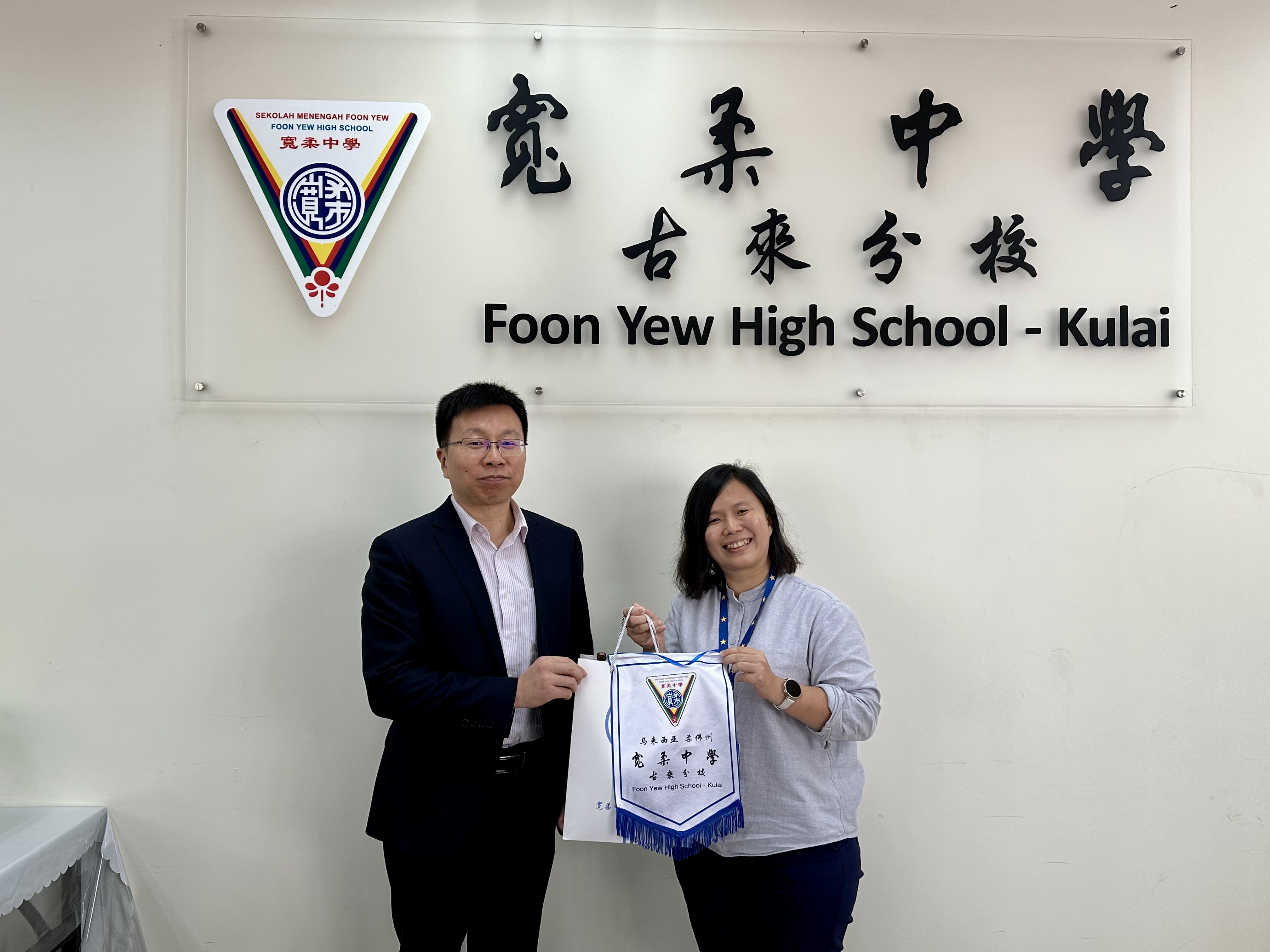 图1：赠送纪念品（左边：教授兼机械工程系主任孙孝飞 ，右边：郑叶枫副校长）