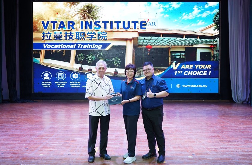 童星存董事长（左）与吴坤达校长（右）一同赠送纪念品予拉曼技职学院执行长陈清凉女士（中）。