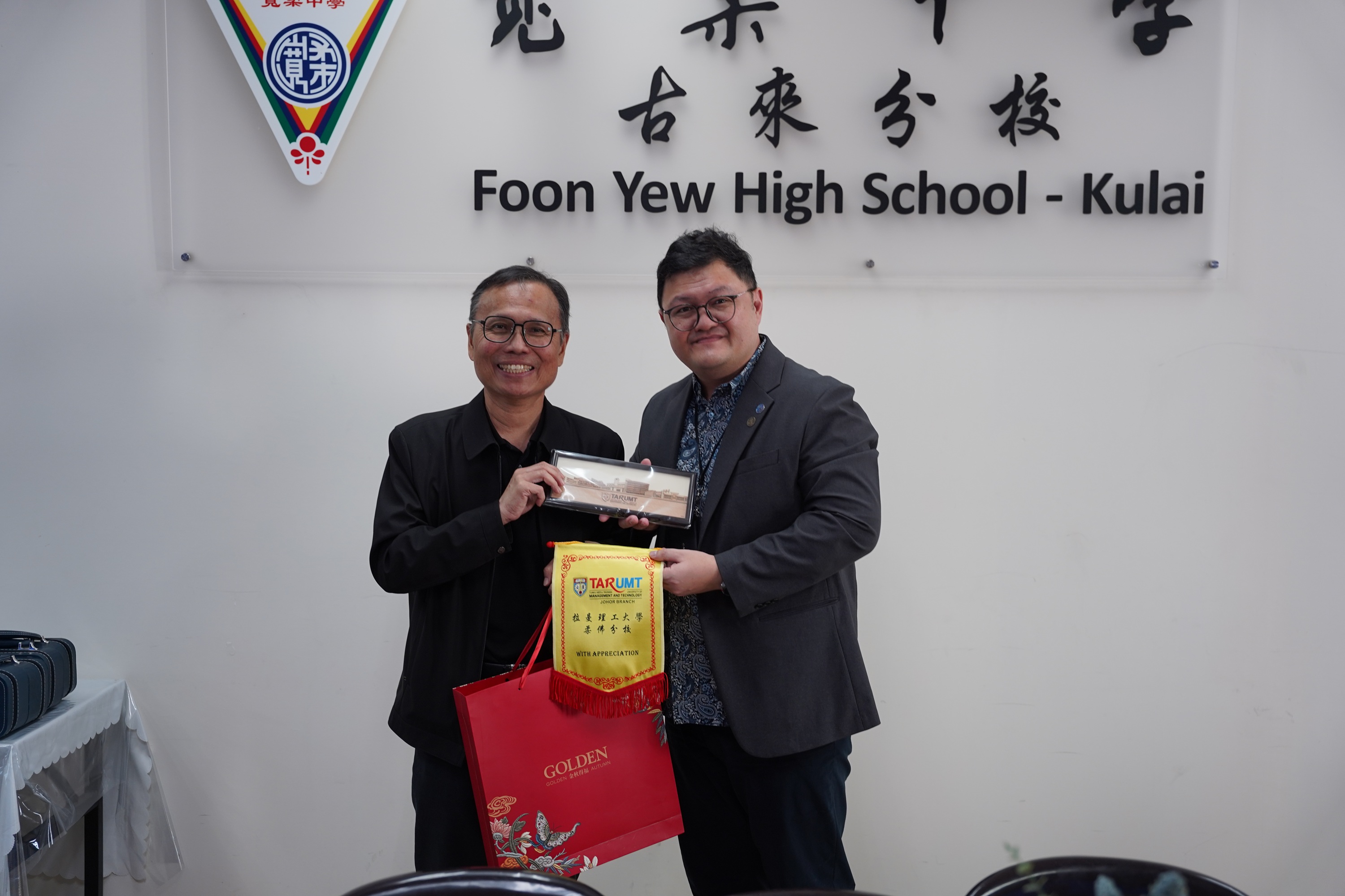（右起）拉曼理工大学校长拿督李仕伟教授赠送纪念品予吴坤达校长并合影留念。