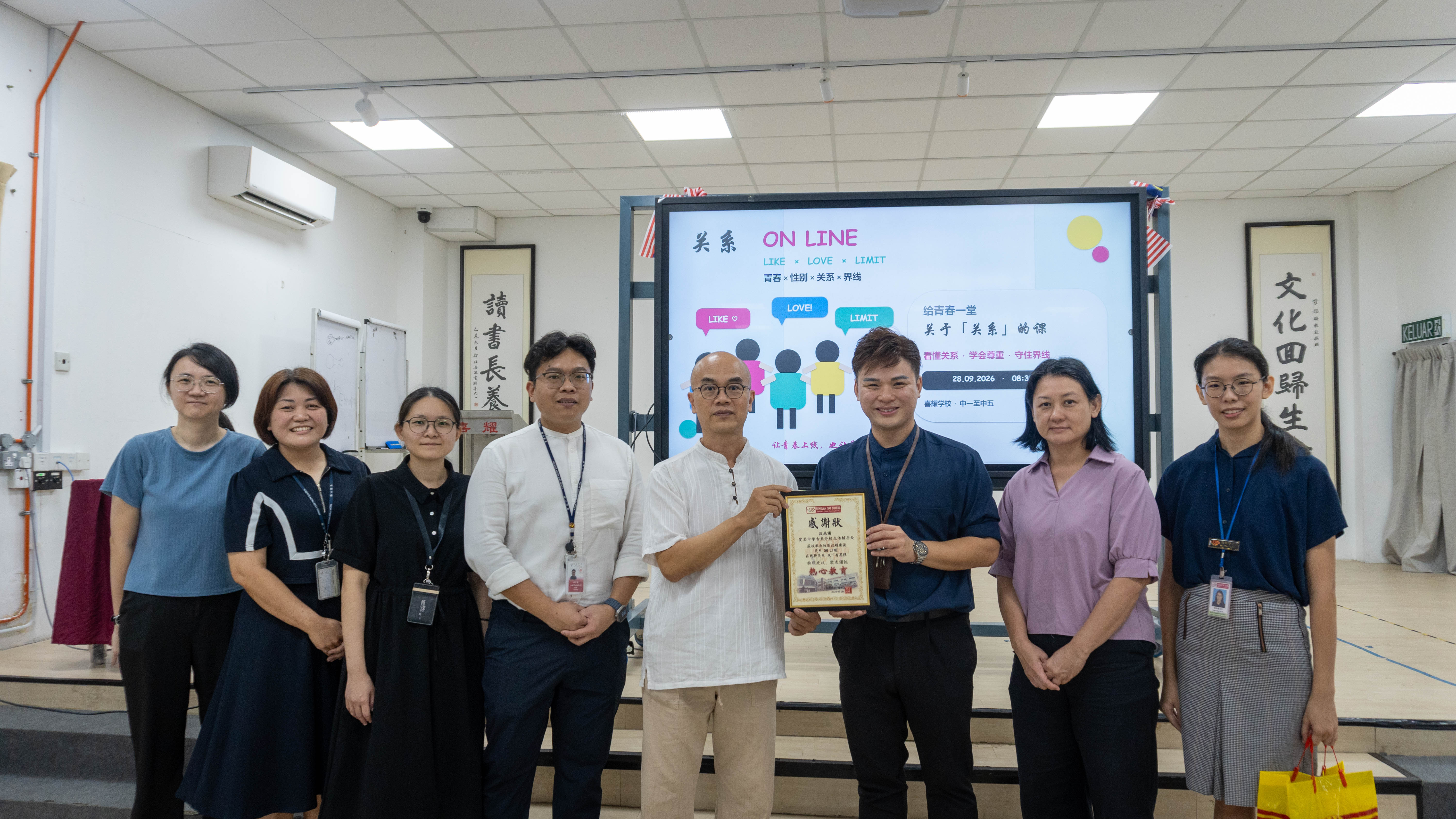 喜耀学校代表向宽柔中学古来分校生活辅导处团队赠送感谢状并合影留念